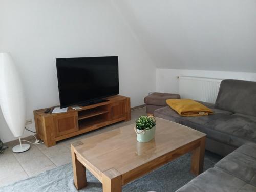 a living room with a flat screen tv and a coffee table at Ferien- und Pferdehof Egelkraut "Feriendomizil am Meer" in Wangerland
