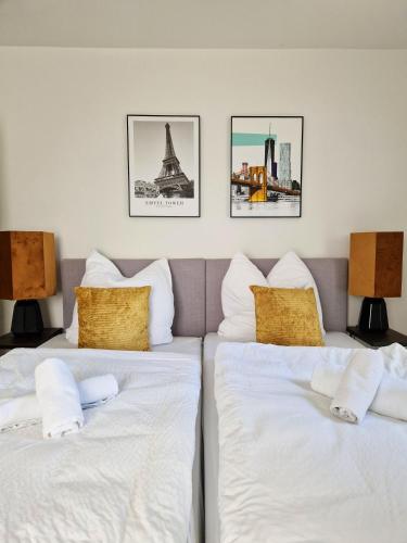 two beds in a room with pictures on the wall at ARGENTA Living 15 in Fulda