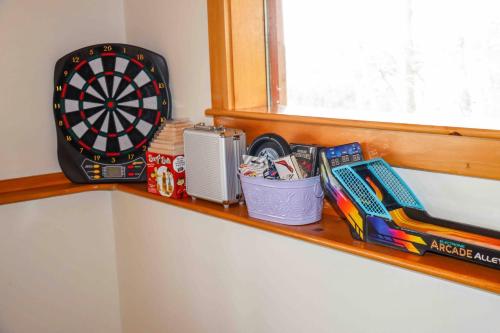a shelf with a dart board and other items on it at Lake Christopher Cabin in Bryant Pond