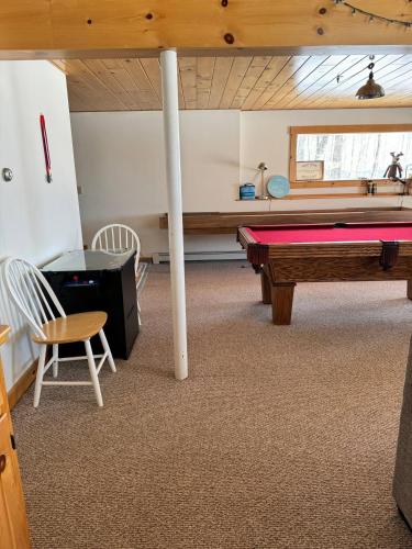 a room with a pool table and a table at Lake Christopher Cabin in Bryant Pond