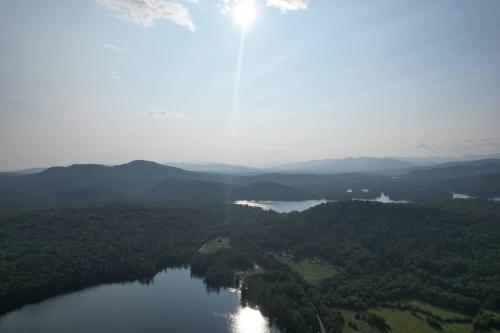 an aerial view of a lake with mountains and forests at Lake Christopher Cabin in Bryant Pond