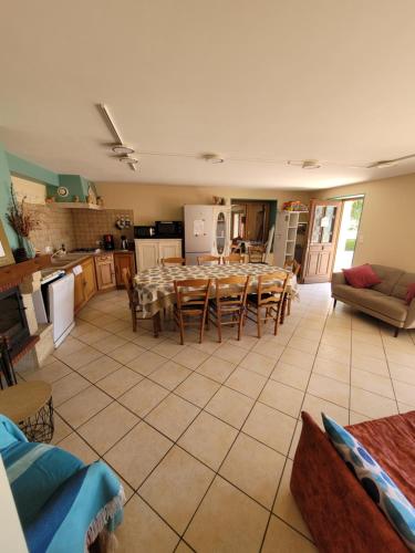 Una cocina y una sala de estar con mesa y sillas. en Chambre d'hôtes , kenya, le petit cocon d'auré, en Corbelin