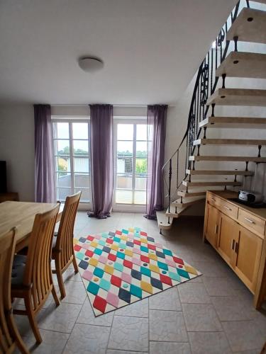 a living room with a staircase and a colorful rug at Ferien- und Pferdehof Egelkraut "Feriendomizil am Meer" in Wangerland