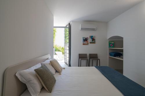 a bedroom with a bed with white sheets and pillows at GuestHost - Lake View Apartment Villa Maderni Como in Cavallasca