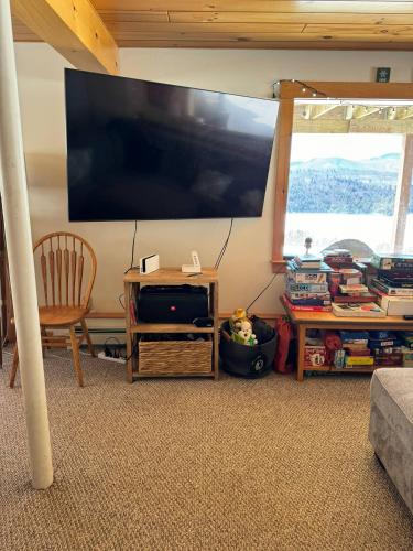 a living room with a large flat screen tv on the wall at Lake Christopher Cabin in Bryant Pond