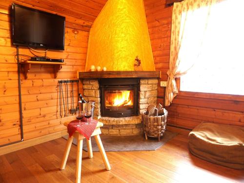 a living room with a fireplace in a log cabin at Alpine Getaway in Tuscany in Cutigliano