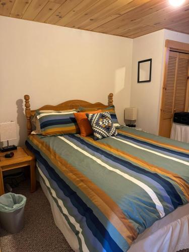 a bed with a colorful comforter in a bedroom at Lake Christopher Cabin in Bryant Pond