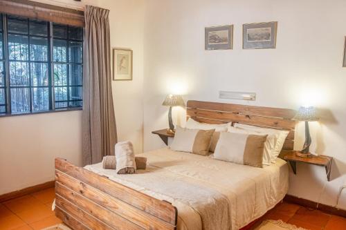 ein Schlafzimmer mit großem Bett und Fenster in der Unterkunft Owl House Marloth Park in Marloth Park