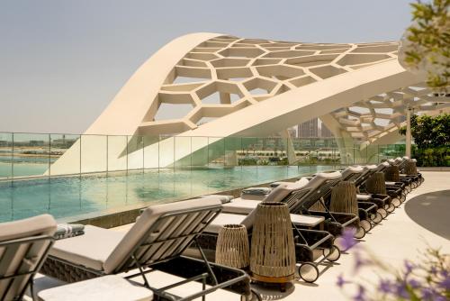 a row of chairs sitting in front of a building at Rosewood Doha in Doha