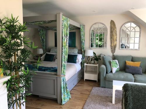 a bedroom with a bed and a couch at The Nest Danehill in Haywards Heath