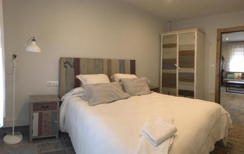 a bedroom with a large bed with white sheets and pillows at Casa Bardenas - La Casica Bardenera in Valtierra