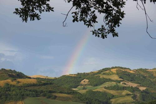 a rainbow in the sky over a mountain at Agriturismo Biologico Villa Rosa in Monte Guiduccio