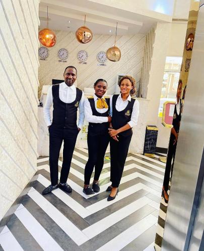 a man and two women standing in a hallway at Olive Ikeja Hotel in Ikeja