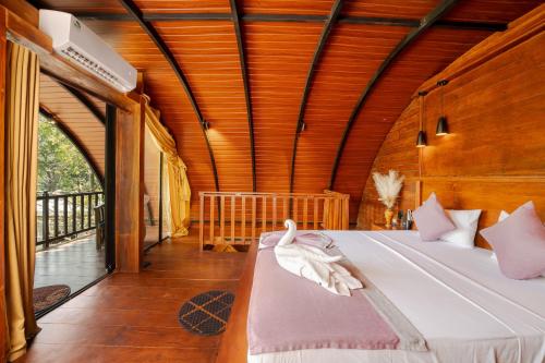 a bedroom with a bed in a room with wooden ceilings at woodland sanctuary in Habarana