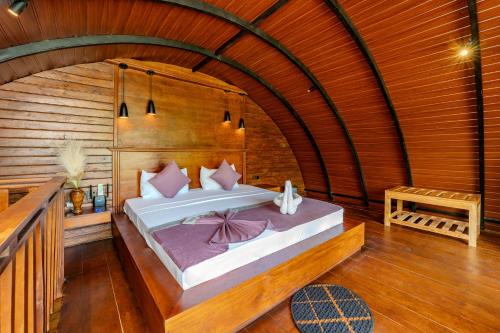 a bedroom with a bed in a wooden room at woodland sanctuary in Habarana