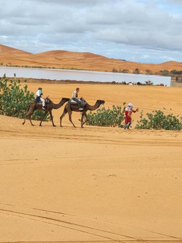 Quelques personnes à cheval dans le désert dans l'établissement Salam Luxury Camp, à Merzouga