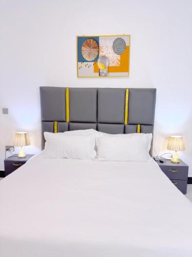 a bedroom with a large white bed with two lamps at Mody Haven in Kampala