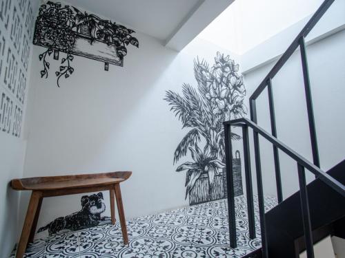 a staircase with a mural of a plant on the wall at Hostel Lullaby Non-Smoking in Chiang Mai