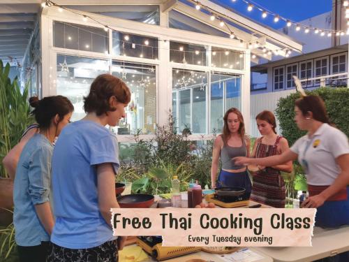 a group of women standing around a table with a cooking class at Hostel Lullaby Non-Smoking in Chiang Mai
