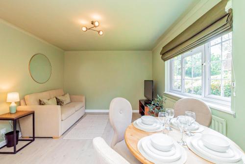 a living room with a table and chairs and a couch at Fresh, stylish apartment in Sherborne Saint John
