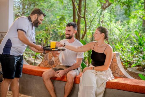 a man handing a tray of food to a woman at woodland sanctuary in Habarana