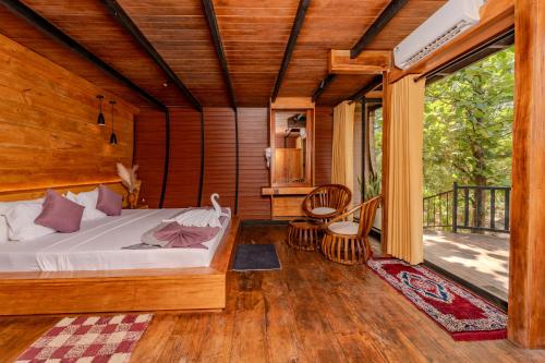a bedroom with a bed and a large window at woodland sanctuary in Habarana