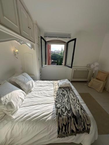 a bedroom with a large bed with a blanket on it at Villa la Tourelle in Théoule-sur-Mer