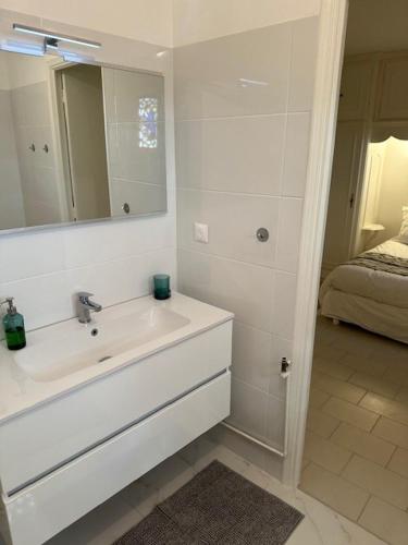 a white bathroom with a sink and a mirror at Villa la Tourelle in Théoule-sur-Mer