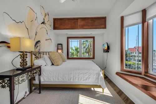 a bedroom with a bed and two windows at The Gulfview Grandeur in Pensacola Beach
