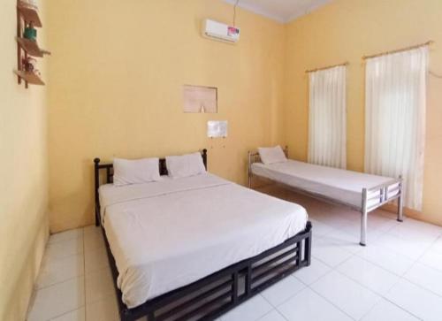 Un dormitorio con dos camas en una habitación. en Homestay El Shaday, en Banyuwangi