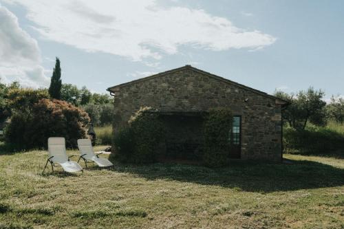 two chairs in front of a stone building at Laura in Rapale
