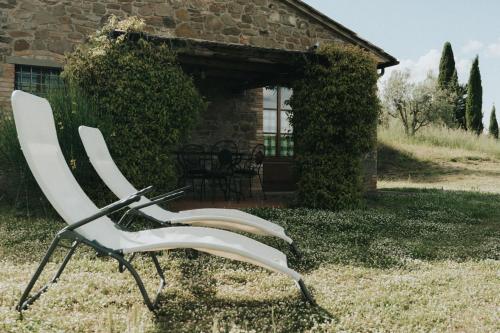 a white chair sitting in the grass in front of a building at Laura in Rapale
