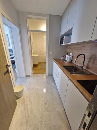 a kitchen with white cabinets and a sink at Apartmani i sobe Martina 2-Self check in in Osijek