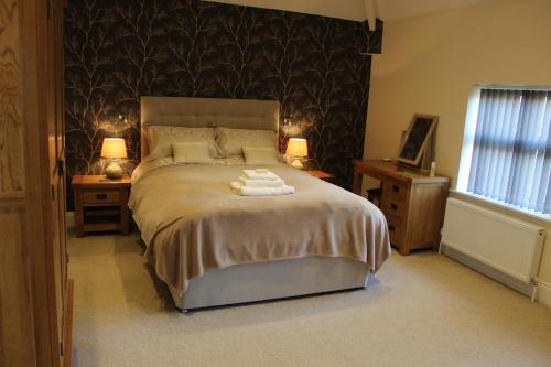 a bedroom with a large bed with two lamps and two tables at A Family Apartment in Sleights - 2D Lowdale Lane in Sleights