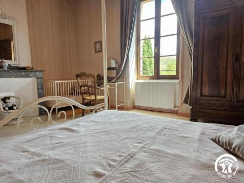 a bedroom with a large bed and a window at Roumanieu le gite in Saint-Gauzens