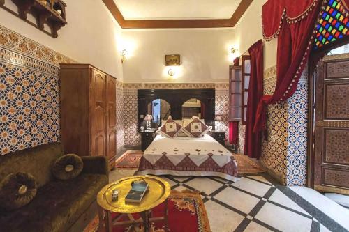 een slaapkamer met een bed en een bank bij Dar Ahl Tadla in Fès