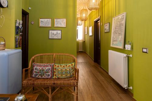 a room with green walls and a chair with a pillow at il Palchetto B&B di Charme e Design in Palermo