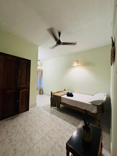 a room with a bed and a ceiling fan at BEACHO 2 bhk private entire villa southcliff varkala in Varkala