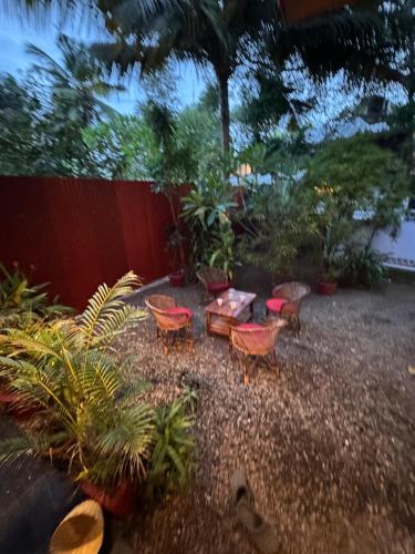 a garden with a table and chairs and a fence at BEACHO 2 bhk private entire villa southcliff varkala in Varkala