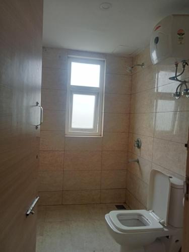 a bathroom with a toilet and a window at Vrindavan Omex in Vrindāvan