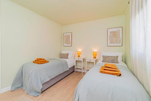 two beds in a white room with a desk and a bed sidx sidx at Fresh, stylish apartment in Sherborne Saint John