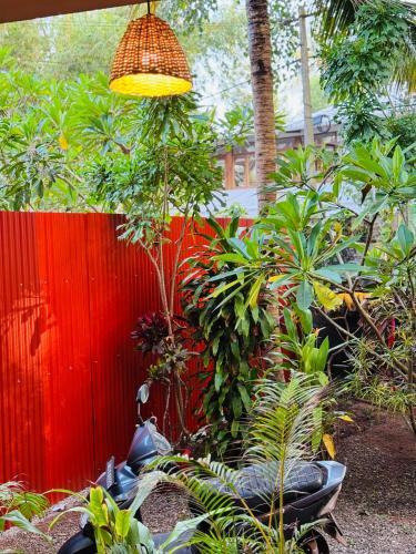 a garden with a red fence and a light at BEACHO 2 bhk private entire villa southcliff varkala in Varkala