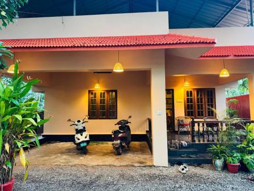 two motorcycles parked in front of a house at BEACHO 2 bhk private entire villa southcliff varkala in Varkala