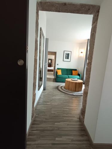 a hallway leading to a living room with a green couch at Le Mas des Loges - Les Vans / Chambonas in Chambonas