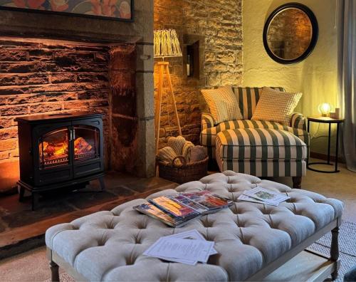 a living room with a couch and a fireplace at Holdsworth House Hotel in Halifax