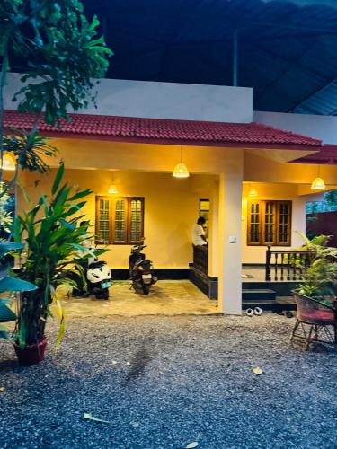 a small yellow house with a panda sitting in front of it at BEACHO 2 bhk private entire villa southcliff varkala in Varkala