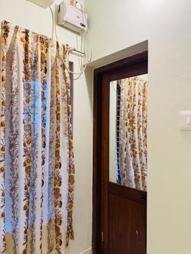 a room with a curtain and a door at BEACHO 2 bhk private entire villa southcliff varkala in Varkala