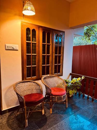 two chairs sitting on a porch next to a window at BEACHO 2 bhk private entire villa southcliff varkala in Varkala
