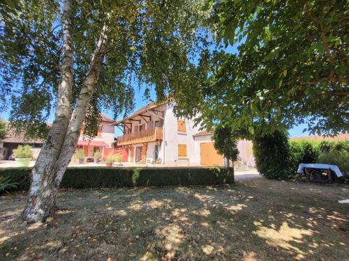 une maison avec un arbre devant dans l'établissement Chambre d'hôtes, coquelicot, le petit cocon d'auré, à Corbelin