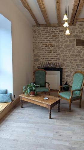 a living room with two chairs and a coffee table at Auberge de la Belette Cendrée in Saint-Léger-sous-Beuvray